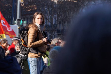 Foto de Toulouse, Francia - Feb. 2023 - Una joven fotógrafa de prensa tomando fotos y asegurando la cobertura de los medios en una manifestación dirigida por organizaciones de izquierda contra la reforma de las pensiones del gobierno - Imagen libre de derechos