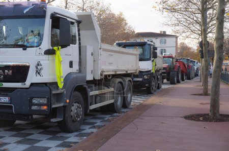 Téléchargez les photos : Albi, France - 1er décembre 2018 - Bloc routier tenu par des camionneurs à gilet jaune, des agriculteurs et des travailleurs du secteur de la construction avec une ligne de camions et de tracteurs sur la place Jean Jaurs, pour protester contre E. Macron - en image libre de droit