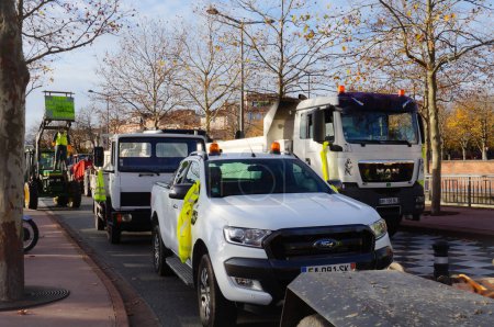 Photo for Albi, France - Dec. 1, 2018 - Construction sector-workers' trucks in a yellow vest roadblock, in Place Jean Jaures, and a model hanged to a tractor with a banner saying "People's death under Macron" - Royalty Free Image
