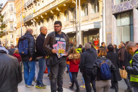 Foto de Toulouse, Francia - Feb. 2020 - Activistas de extrema izquierda distribuyen el periódico marxista Revolución, titulado "Ira general", en una manifestación de Chalecos amarillos y sindicatos contra la reforma de las pensiones - Imagen libre de derechos