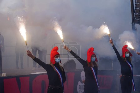 Foto de París, Francia - 10 de octubre de 2020 - Las "Mariannes", jóvenes partidarias de La Manif pour Tous, lanzan bombas de humo en la manifestación de Marchons Enfants contra la esclavitud moderna y la maternidad sustituta gestacional - Imagen libre de derechos