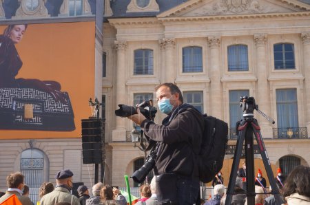 Téléchargez les photos : Paris, France - 10 octobre 2020 - Un photographe de presse, masqué et équipé de deux caméras, prend des photos lors de la manifestation des enfants Marchons contre le projet de loi sur la bioéthique du gouvernement - en image libre de droit