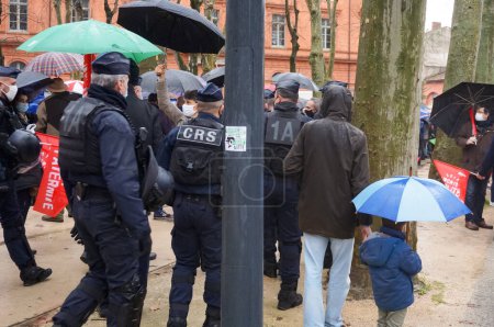 Téléchargez les photos : Toulouse, France - 30 janvier 2021 - Intervention de policiers CRS (contrôle des foules) lors d'une manifestation pro-famille Marchons Enfants sur la Place du Salin, en mouvement pour chasser les perturbateurs d'Antifa - en image libre de droit