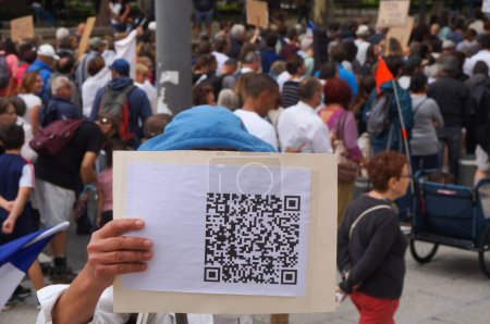 Téléchargez les photos : Albi, France - 31 juillet 2021 - Un manifestant montre un faux code QR imprimé, lors d'une manifestation contre le mandat de vaccination des agents de santé et le passeport sanitaire ("green pass") sur Lices Jean Moulin - en image libre de droit