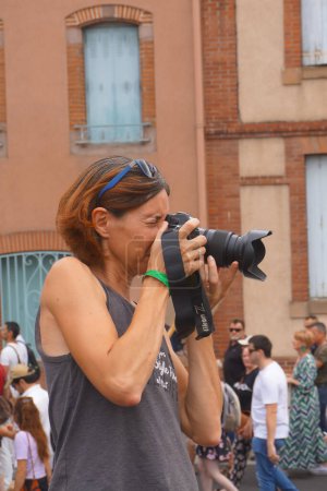 Photo for Albi, France - July 24, 2021 - The female photographer of "La Depeche du Midi" takes images of the manifestation against compulsory vaccination for health workers and sanitary pass (green pass) - Royalty Free Image