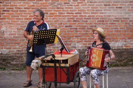 Téléchargez les photos : Albi, France - 4 septembre 2021 - Deux artistes de rue, une femme et un homme, jouent de l'accordéon et de la trompette, en marge d'une manifestation contre les mesures Covid, le laissez-passer vert et le mandat de vaccination - en image libre de droit