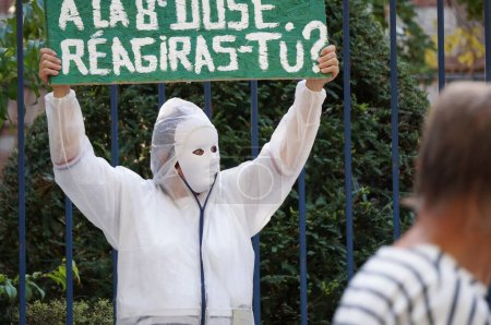Téléchargez les photos : Albi, France - Novembre 2021 - Des manifestants en blouse blanche d'hôpital, portant des masques de mascarade, descendent dans les rues du centre-ville avec des pancartes, pour exposer les restrictions Covid-19 et les mandats de vaccination - en image libre de droit