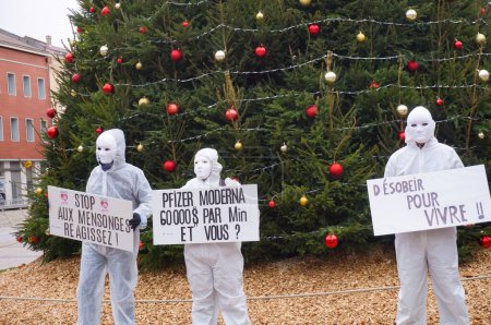 Foto de Albi, Francia - Nov. 2021 - Manifestantes en batas blancas de hospital, con máscaras de mascarada, salen a las calles en el centro de la ciudad con pancartas, para exponer las restricciones de Covid-19 y los mandatos de vacunación - Imagen libre de derechos
