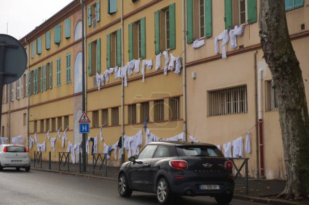 Téléchargez les photos : Albi, France - Juillet 2021 - Manteaux blancs suspendus aux fenêtres de la clinique Bon Sauveur, pour protester contre les conditions de travail des fournisseurs de soins de santé à l'hôpital, au milieu de la suspension des soignants non vaccinés - en image libre de droit