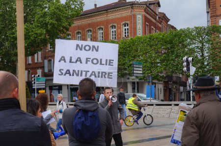 Foto de Albi, Francia - 1 de mayo de 2021 - Una pancarta que dice "No a la locura sanitaria" en una manifestación en la Plaza Le Vigan denunciando las medidas libertadoras tomadas en medio de la pandemia del coronavirus - Imagen libre de derechos