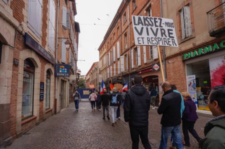 Foto de Albi, Francia - 1 de mayo de 2020 - Marcha anticonfinamiento contra las restricciones sanitarias, organizada por partidos de derecha en la Ciudad Vieja; un manifestante lleva una pancarta que dice: "Vivamos y respiremos" - Imagen libre de derechos