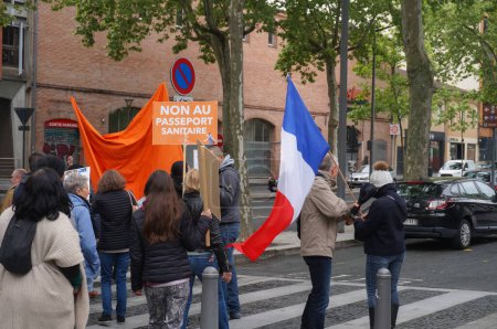 Foto de Albi, Francia - 1 de mayo de 2021 - Marcha contra el bloqueo y las medidas sanitarias represivas organizadas por partidos políticos de derecha y soberanos en el centro de la ciudad; manifestantes portan una bandera y pancartas francesas - Imagen libre de derechos