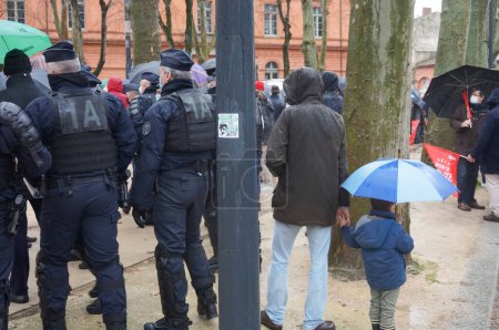 Photo for Toulouse, France - Jan. 30, 2021 - CRS (crowd control unit) police officers securing a pro family Marchons Enfants demonstration on Place du Salin, on the move to chase away Antifa disrupters - Royalty Free Image