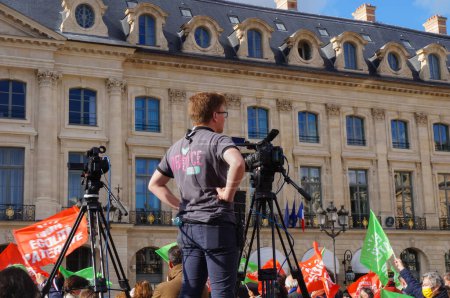 Foto de París, Francia - 10 de octubre de 2020 - Un operador de cámara cubre la manifestación de Marchons Enfants contra el proyecto de ley de bioética del gobierno francés frente al Ministerio de Justicia, en Place Vendome - Imagen libre de derechos