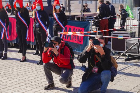 Photo for Paris, France - Oct. 10, 2020 - Press photographers crouching to shoot pictures at Marchons Enfants' manifestation in Place Vendme against the French government's bioethics and procreation bill - Royalty Free Image