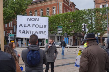 Foto de Albi, Francia - 1 de mayo de 2021 - Una pancarta dice "No a la locura sanitaria" en una manifestación en la Plaza Le Vigan organizada por partidos políticos de derecha que se oponen a las medidas sanitarias represivas - Imagen libre de derechos