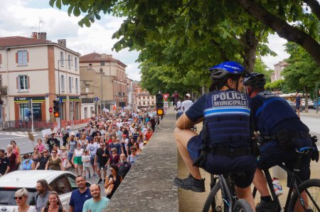 Foto de Albi, Francia - 17 de julio de 2021 - Los ciclistas de la Policía Municipal monitorean la larga procesión de manifestantes que se manifiestan contra la vacunación obligatoria de los trabajadores de la salud y el "pase sanitario" (pase verde)) - Imagen libre de derechos