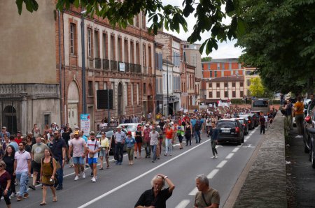 Photo for Albi, France - Aug. 14, 2021 - Crowd of protesters marching on Hippolyte Savary Street, at a demonstration against green passport, Covid-19 measures and vaccine mandate for healthcare workers - Royalty Free Image