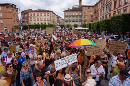 Photo for Albi, France - Aug. 14, 2021 - Crowd of protesters marching on Hippolyte Savary Street, at a demonstration against green passport, Covid-19 measures and vaccine mandate for healthcare workers - Royalty Free Image