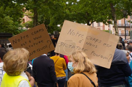 Foto de Albi, Francia - 31 de julio de 2021 - Placas que dicen: "Nuestro cuerpo es nuestro, ¿por qué una dictadura?" blandido por dos mujeres mayores en una manifestación contra el mandato de la vacuna para los trabajadores de la salud y "pase verde" - Imagen libre de derechos