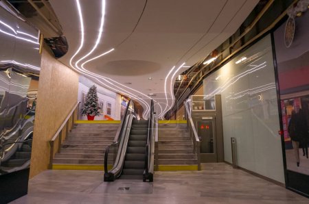 Foto de Toulouse, Francia - dic. 2019- Pasillo dentro del centro comercial subterráneo "Espace Saint-Georges", con escaleras, escaleras mecánicas y ascensor para personas de movilidad reducida, suelo de baldosas y luces de tubo de neón en el techo - Imagen libre de derechos