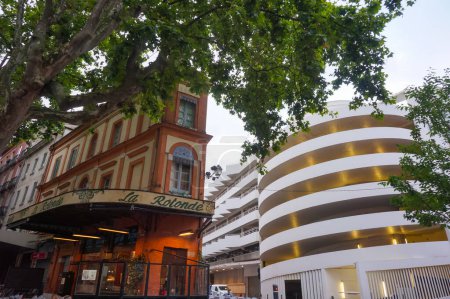 Foto de Toulouse, Francia - Junio 2021 - Edificio de ladrillo rosa de "La Rotonde" (refiriéndose al nombre de un conocido restaurante en París), en Strasbourg Boulevard, junto al aparcamiento de varios pisos Victor Hugo - Imagen libre de derechos