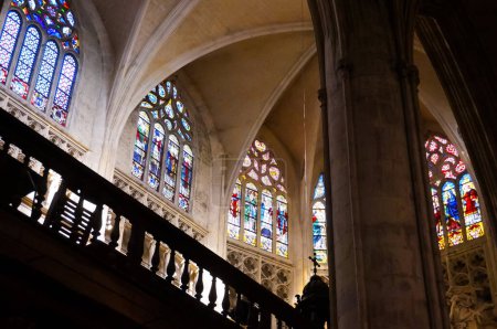 Téléchargez les photos : Intérieur de la cathédrale Saint-Étienne : la nef gothique, au plafond à voûte nervurée, ambulatoire sur le côté et aux vitraux colorés - en image libre de droit