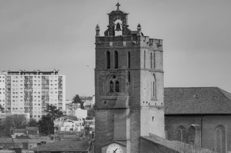 Foto de Vista inusual de pájaro, en una vista focal muy larga, sobre el campanario de ladrillo de la Catedral de Saint-Etienne, en Toulouse, al sur de Francia, con una torre residencial en el fondo (blanco y negro) - Imagen libre de derechos