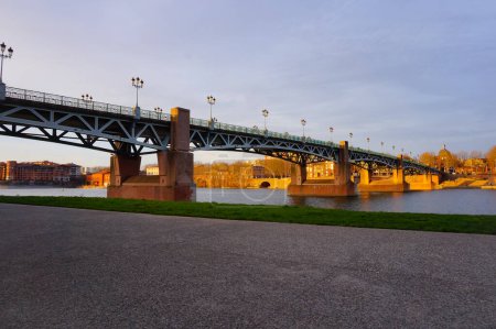 Photo for Girder bridge Pont Saint-Pierre in Toulouse, France, that crosses the River Garonne, seen from the promenade of the riverside of Port Viguerie near Bazacle and Daurade neighborhoods - Royalty Free Image