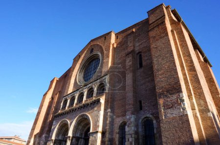 Téléchargez les photos : Western entrance of the well-known Basilica of Saint Sernin, with a fountain in the foreground ; this UNESCO World Heritage site in Toulouse, France, is the largest romanesque church in Europe - en image libre de droit