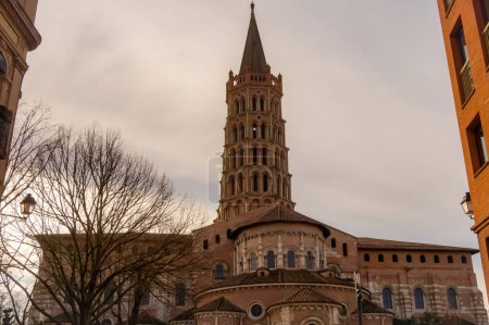 Téléchargez les photos : Toulouse, France - Jan. 2020 - The bell tower of the Basilica of Saint-Sernin, a medieval World Heritage Site and the largest romanesque church in Europe, in the perspective of Saint-Bernard Street - en image libre de droit