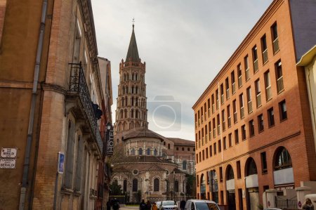 Foto de Toulouse, France - Jan. 2020 - The bell tower of the Basilica of Saint-Sernin, a medieval World Heritage Site and the largest romanesque church in Europe, in the perspective of Saint-Bernard Street - Imagen libre de derechos