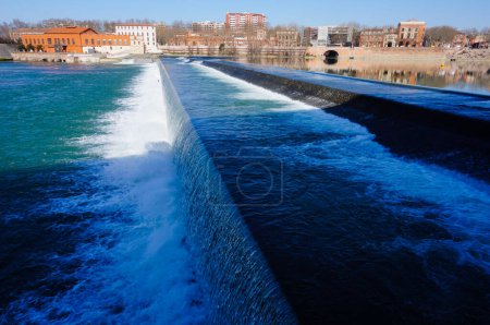 Photo for Toulouse, France - Waterfall producing white foam and whirlpool on the river Garonne, downstream the bridge Pont Saint-Pierre, seen from Viguerie Passerelle, in Saint-Cyprien district - Royalty Free Image