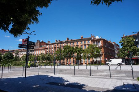 Foto de Toulouse, Francia - 10 de junio de 2023 - Edificios urbanos con fachadas típicas de ladrillo del sur, en Ramblas-Allees Jean Jaures, una calle frondosa, parcialmente peatonal, y la calle más ancha de la ciudad - Imagen libre de derechos