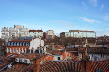 Foto de Vistas a los tejados de tejas de antiguas casas de ladrillo en el barrio de Arnaud Bernard en Toulouse, Francia, rascacielos residenciales y edificios de oficinas en el distrito de Matabiau en el fondo - Imagen libre de derechos