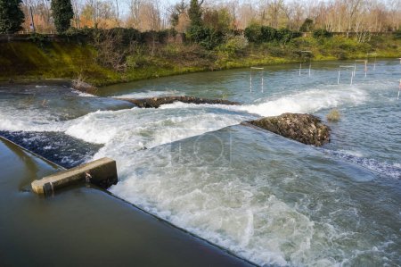 Foto de Water falls, rapids and powerful whirlpools with white foam on the River Garonne in Toulouse, France, seen from the passerelle of Chemin de la Loge between the islands of Grand Ramier and Empalot - Imagen libre de derechos