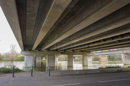 Téléchargez les photos : Bottom view of the prestressed concrete beams and piers of Pont d'Empalot, a girder bridge in Toulouse, France, crossing the River Garonne and supporting the six-lane express way of Toulouse ring road - en image libre de droit