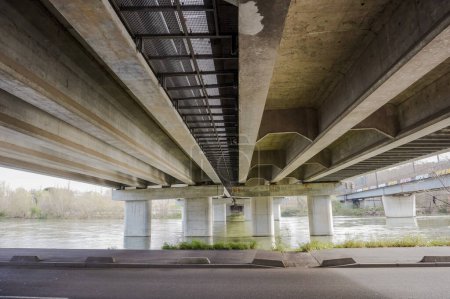 Foto de Bottom view of the prestressed concrete beams and piers of Pont d'Empalot, a girder bridge in Toulouse, France, crossing the River Garonne and supporting the six-lane express way of Toulouse ring road - Imagen libre de derechos