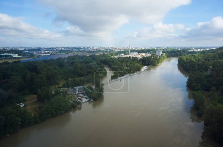 Photo for Toulouse, France - June 4, 2023 - Aerial view from Teleo cable car over the muddy water of the Garonne, after heavy rains; with a side, smaller branch, the river splits on both sides of Empalot Island - Royalty Free Image