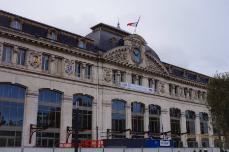 Photo for Toulouse, France - Nov. 2019 - Monumental main facade of Gare de Toulouse-Matabiau, the central railway station of the Rose City, having a big clock, large bay windows and flying the French flag - Royalty Free Image