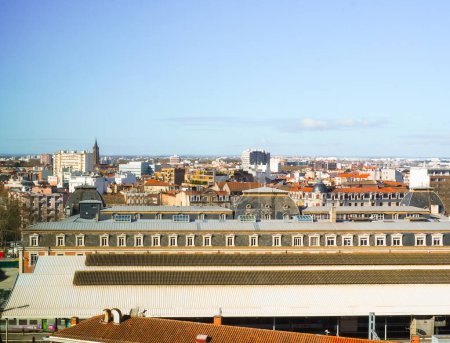 Foto de Vista panorámica de los tejados de los antiguos edificios de ladrillo en los distritos de Matabiau y Marengo en Toulouse, al sur de Francia, con la estación de tren a la vanguardia y la Basílica de Saint-Sernin a lo lejos - Imagen libre de derechos