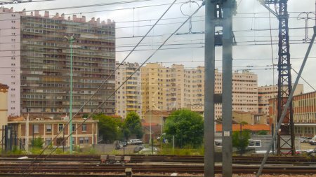 Photo for Toulouse, France - Aug. 2020 - Social housing blocks in the working-class districts of Negreneys and Minimes, seen from the tracks of Matabiau railway station, with overhead lines in the forefront - Royalty Free Image