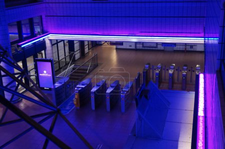 Photo for Toulouse, France - Aug. 2022 - Modern interior of the underground metro station of Matabiau Train Station, illuminated by night with blue and purple lights ; the ticket barriers, seen from above - Royalty Free Image