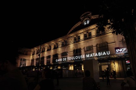 Photo for Toulouse, France - Aug. 2022 - Illuminated facade, by night, of Toulouse-Matabiau Station, with its lighted sign ; the infrastructure is the main train station and multimodal hub in Midi-Pyrenees - Royalty Free Image
