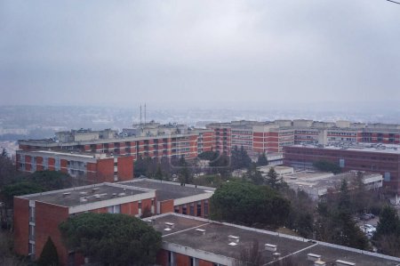 Photo for Toulouse, France - Jan. 2023 - Aerial view from Teleo cable car over the vast, brick facilities of Rangueil University Hospital (CHU Rangueil), on top of Pech-David Hill, by a foggy, cloudy winter day - Royalty Free Image