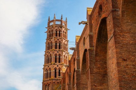 Foto de Exterior del transepto y vista en ángulo bajo del campanario de ladrillo de la Basílica de San Sernin, Patrimonio de la Humanidad por la UNESCO en Toulouse, Francia, y la iglesia románica más grande de Europa - Imagen libre de derechos