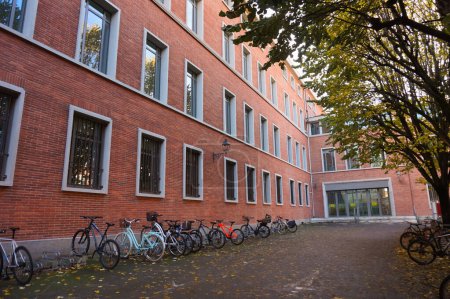 Foto de Toulouse, Francia - Nov. 2019 - Edificio de ladrillo del Liceo Pierre de Fermat, que alberga una escuela secundaria y clases preparatorias para futuros ingenieros; estacionamiento de bicicletas con profesores y bicicletas para estudiantes - Imagen libre de derechos