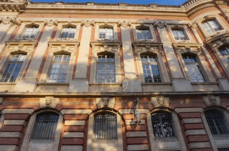 Photo for Back of the Capitole, city hall of Toulouse, France, featuring an imposing brick classic facade with massive columns, a balcony with balustrade and a fronton bearing the inscription "French Republic" - Royalty Free Image