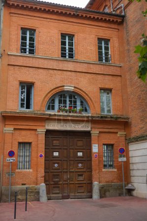Foto de Toulouse, Francia - Julio 2020 - Puerta de madera y ventana arqueada en la entrada histórica del edificio de ladrillo de la antigua Escuela de Bellas Artes, ahora llamada ISDAT, en la calle Quai de la Daurade - Imagen libre de derechos