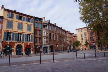 Foto de Toulouse, Francia - Nov. 2019 - Típicas y tradicionales casas adosadas de madera y ladrillo con Toulouse Catholic Institute (ICT) en Parliament Square (Place du Parlement) y Salin Square (Place du Salin) - Imagen libre de derechos